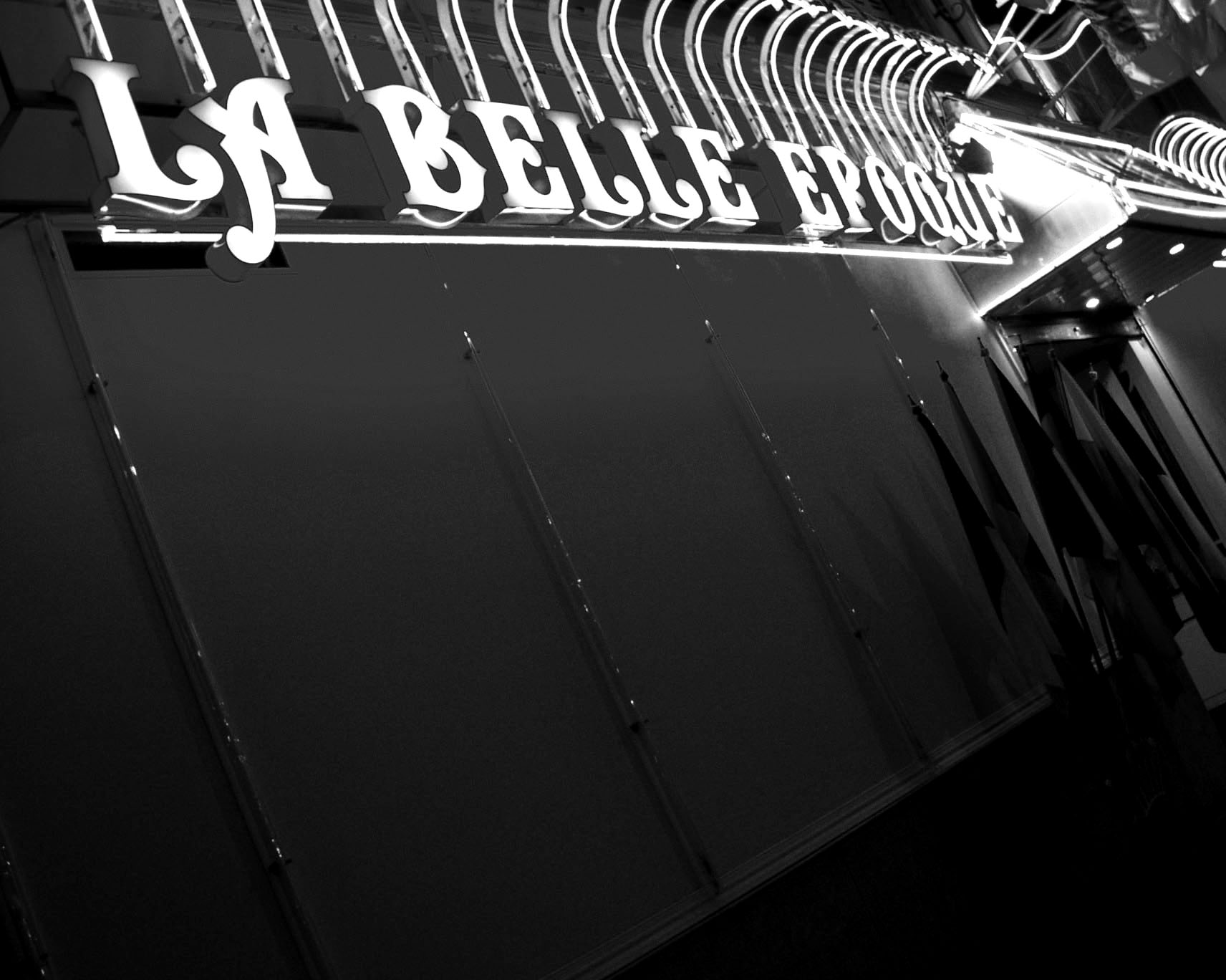 Illuminated sign reading La Belle Epoque above a dark shopfront