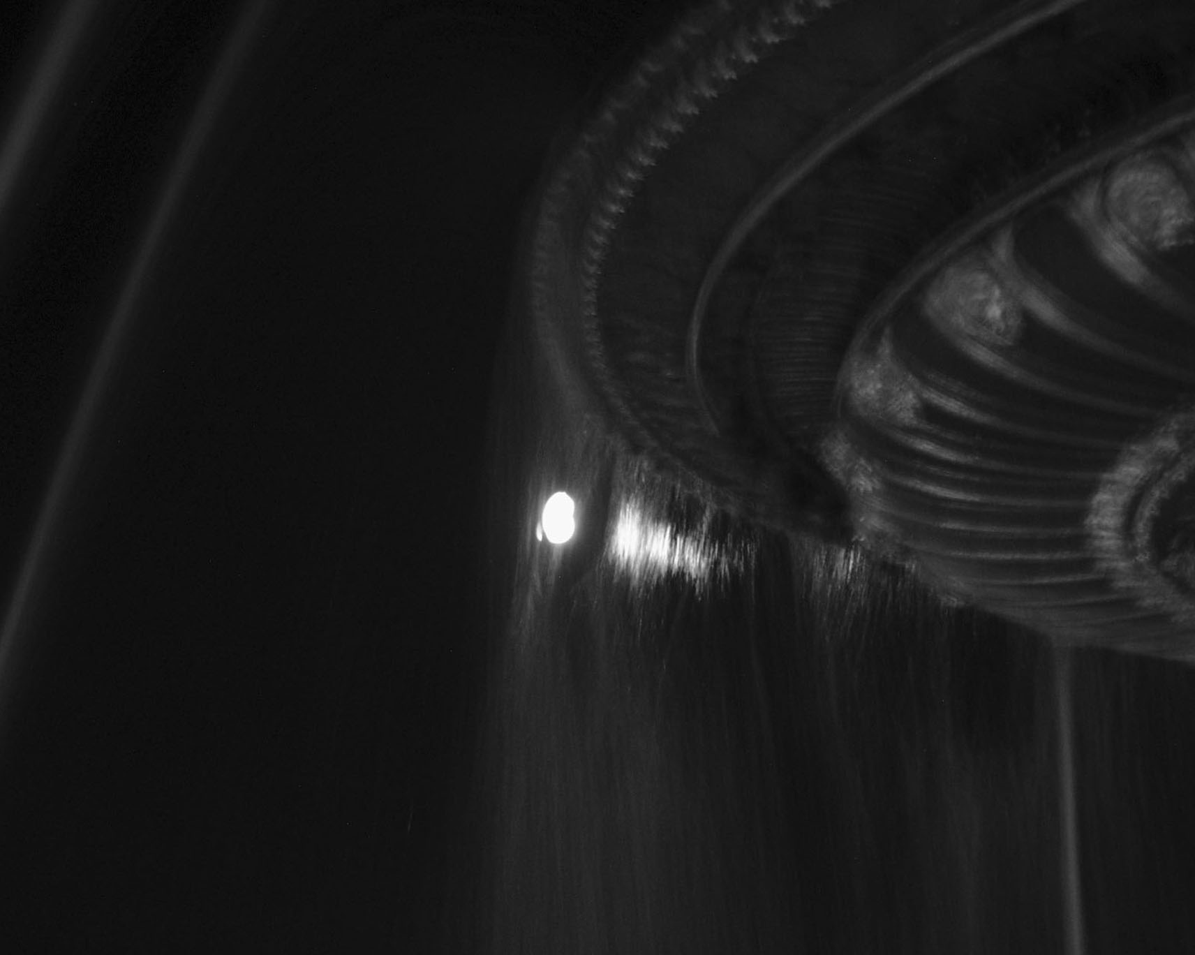 Blurred light on the curves of an ornate fountain in the dark