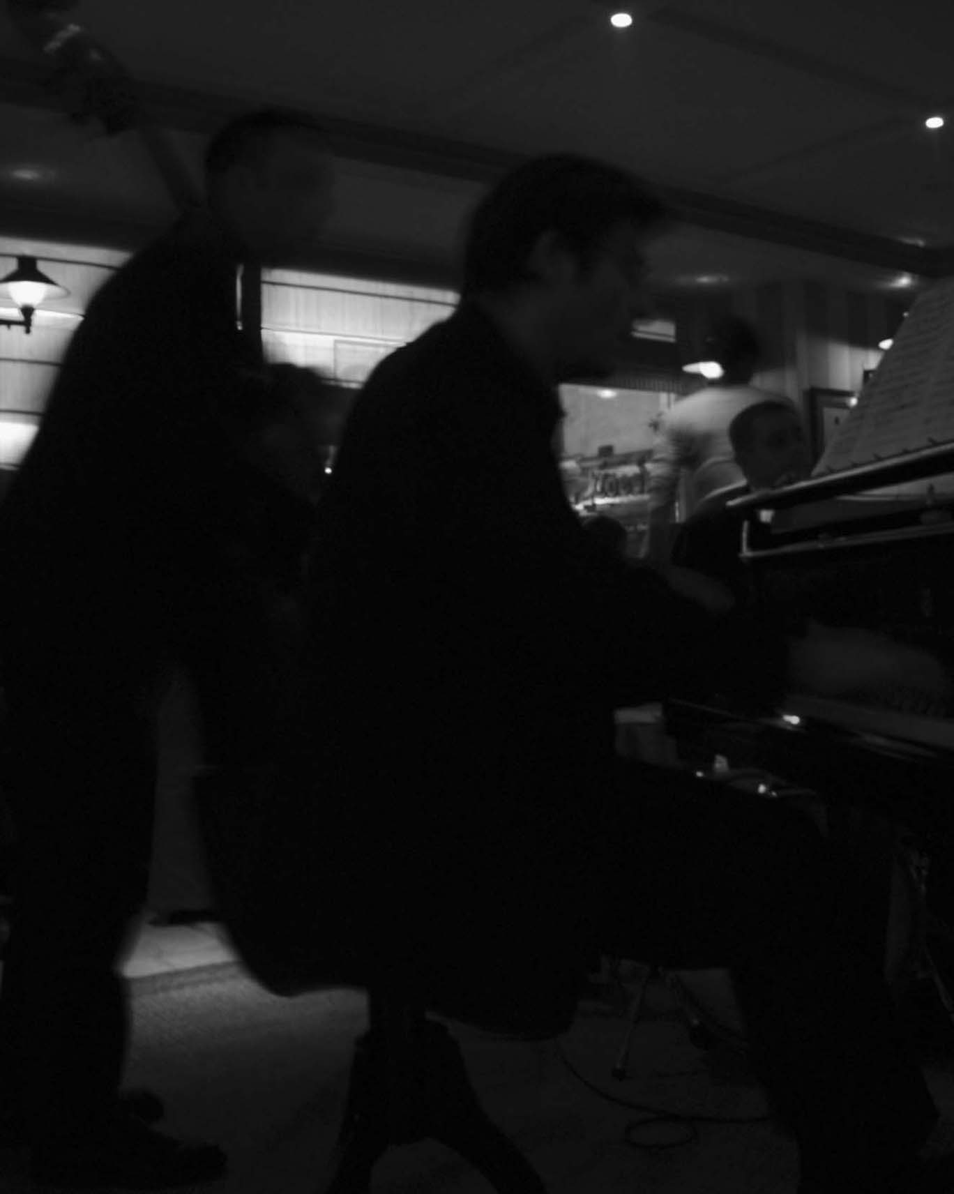 Two blurred figures at a piano in a jazz bar