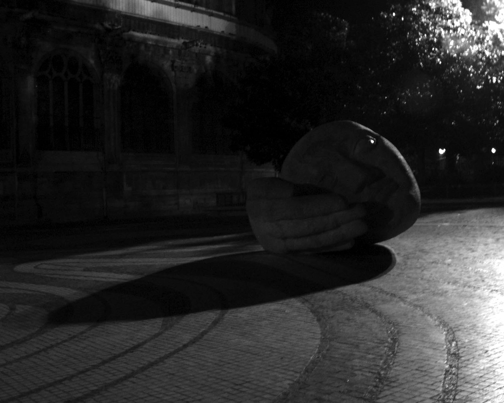 Large sculpture of a head resting on its hand, Saint-Eustache, at night