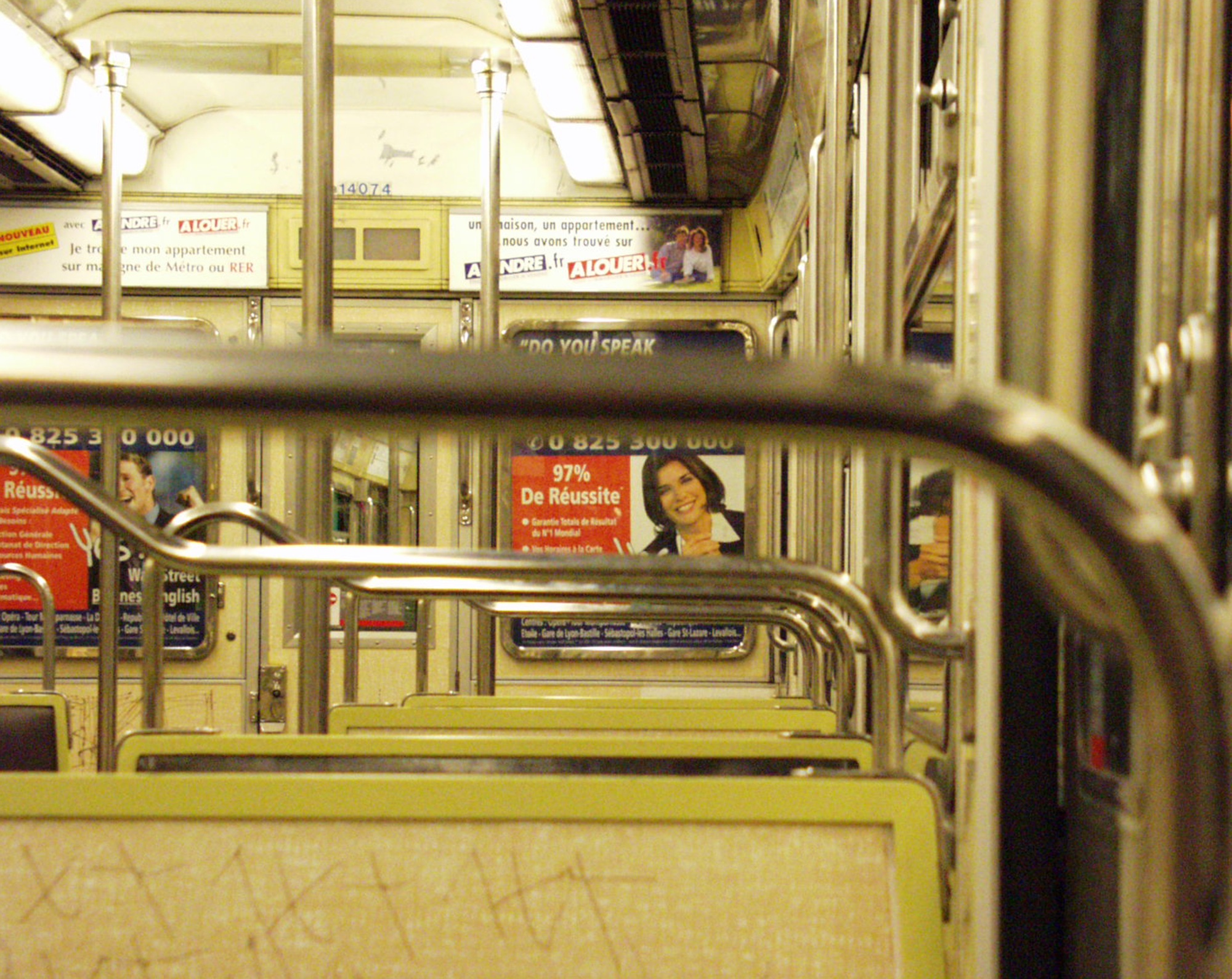 Empty métro carriage with yellow seats and steel rails
