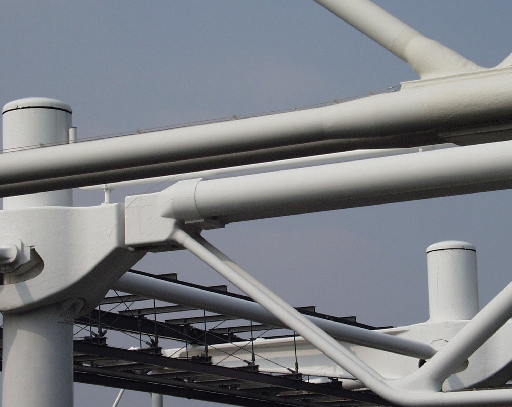 White steel tubes crossing against a blue sky