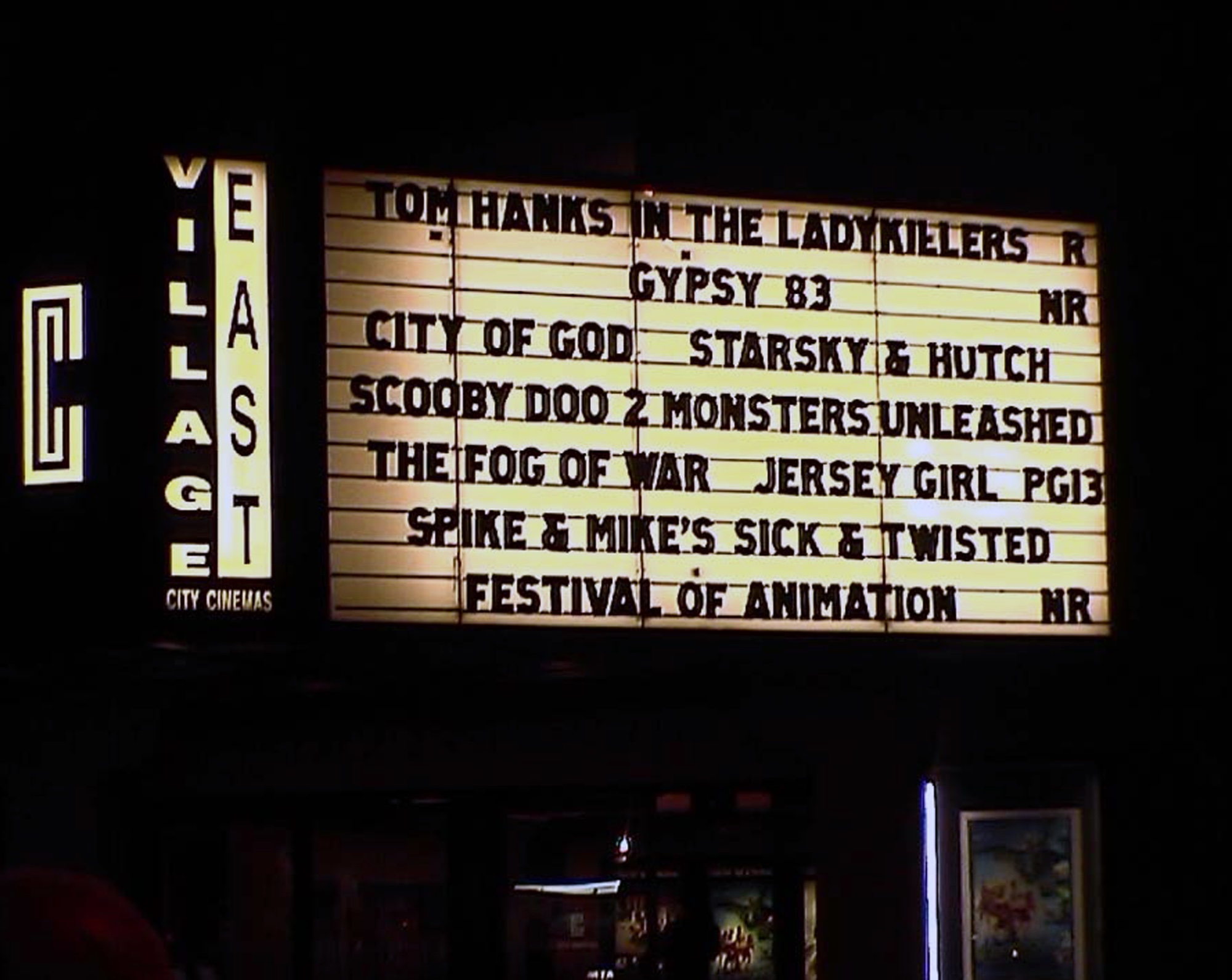 Village East cinema marquee at night listing films