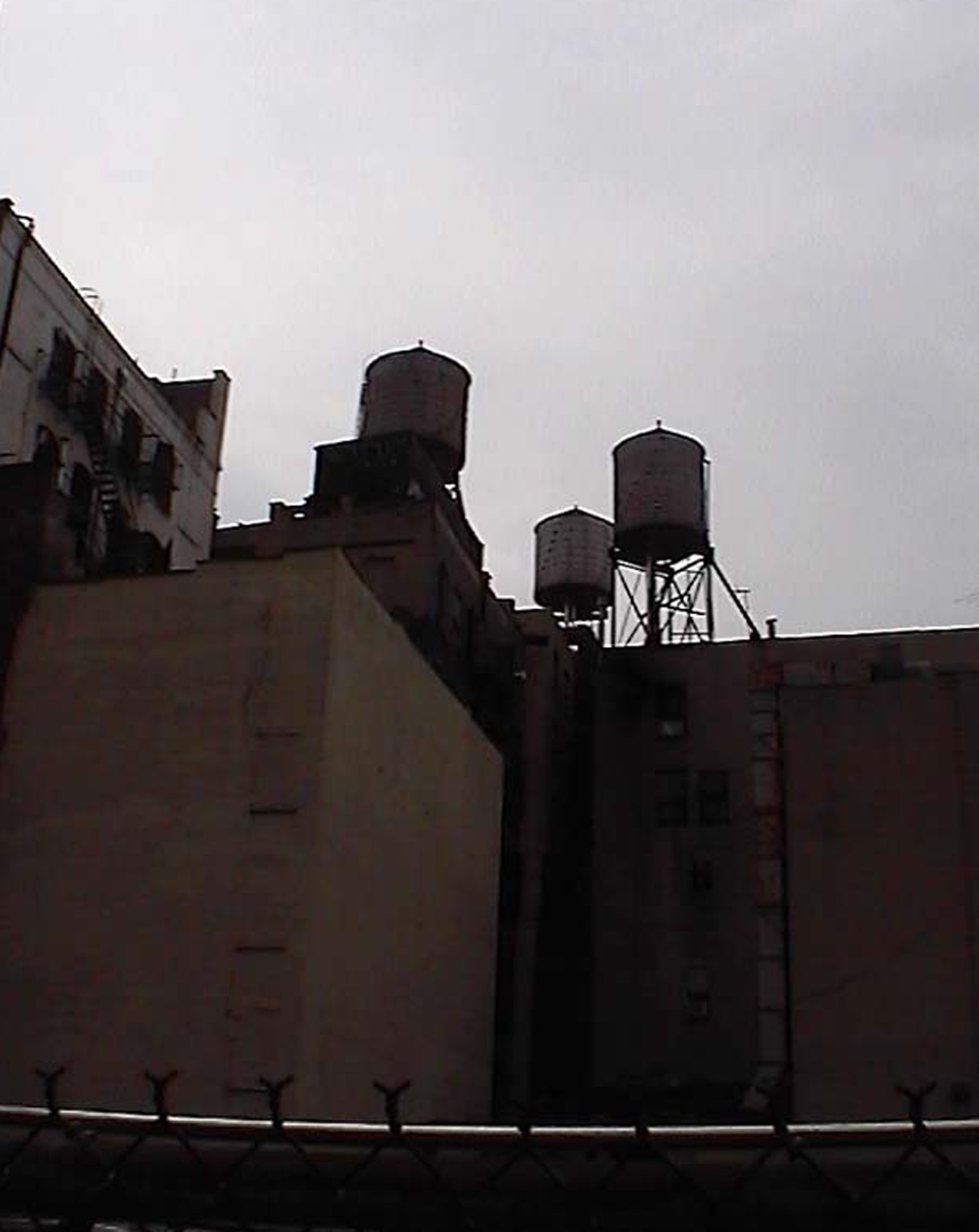 Water towers on New York rooftops against a grey sky