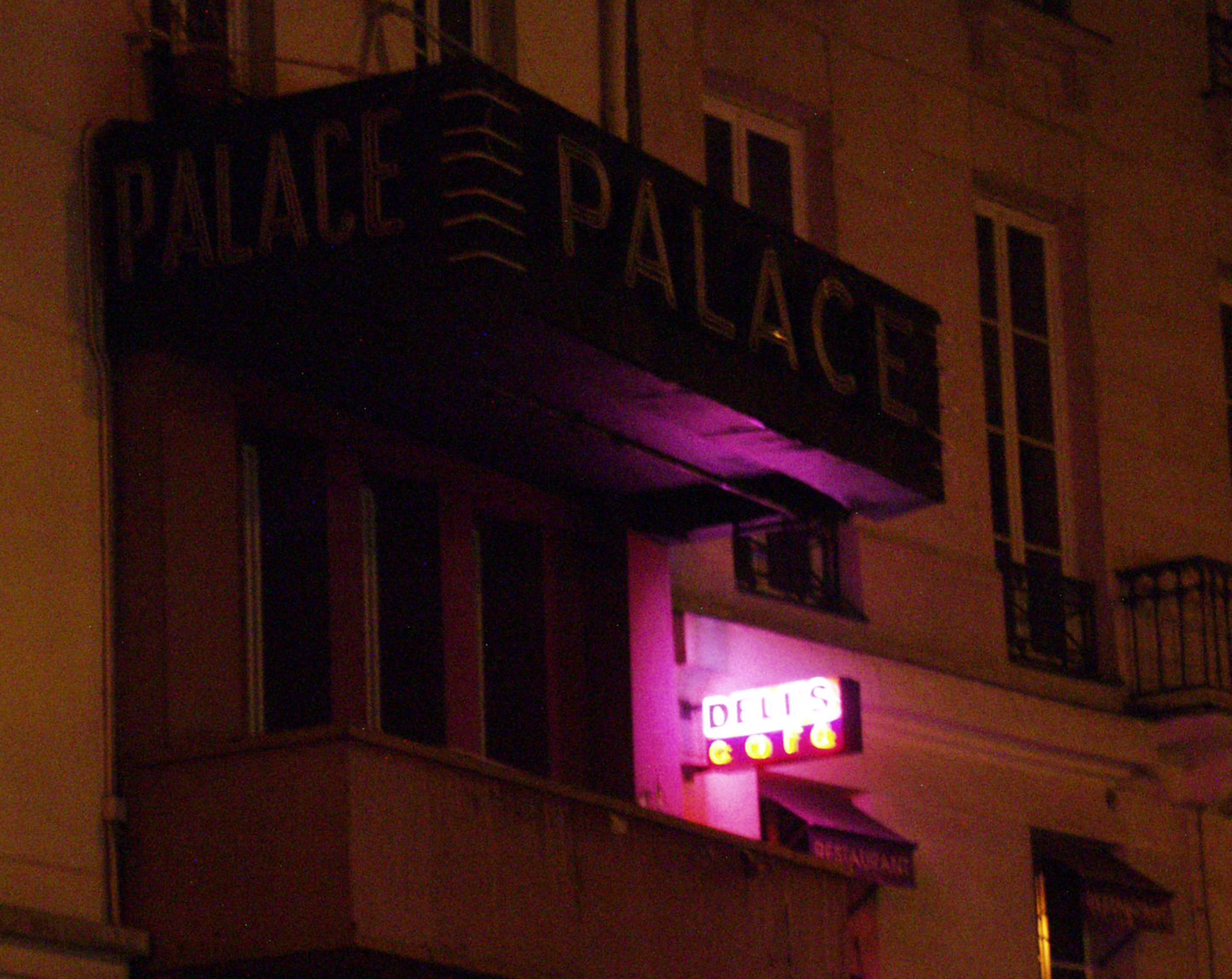 Old Palace sign on a balcony, a small pink neon lit below