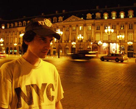 The young man in Place Vendôme at night, a car streaking past