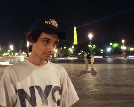 The young man at Place de la Concorde, the Eiffel Tower small and lit behind him