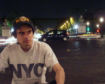 The young man sitting on the ground at the foot of the Champs-Élysées, traffic behind