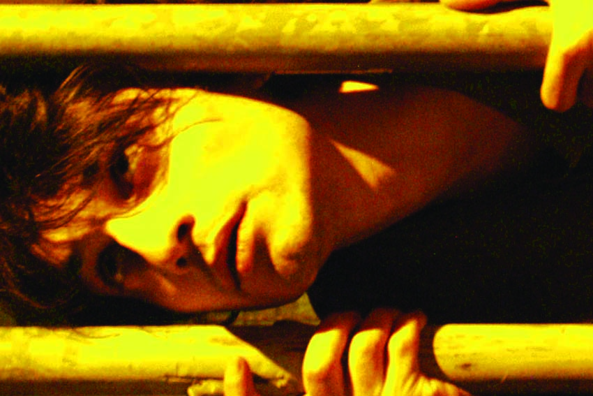 Face sideways between horizontal bars, hands gripping them