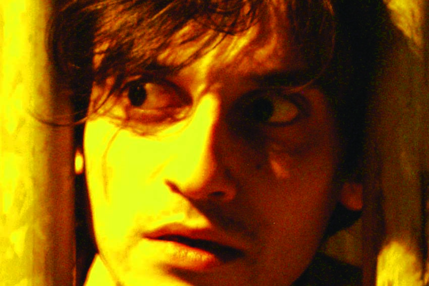 Close face with wide eyes glancing sideways in yellow light