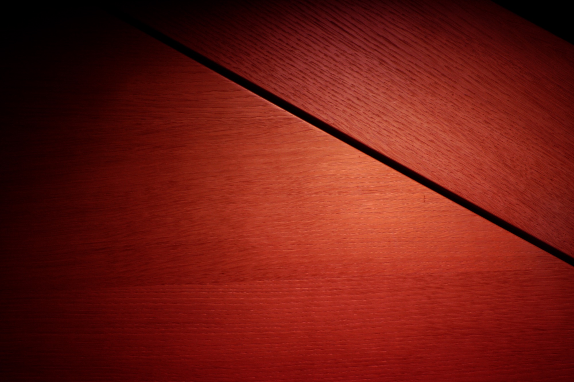 Red wood grain split by a dark diagonal