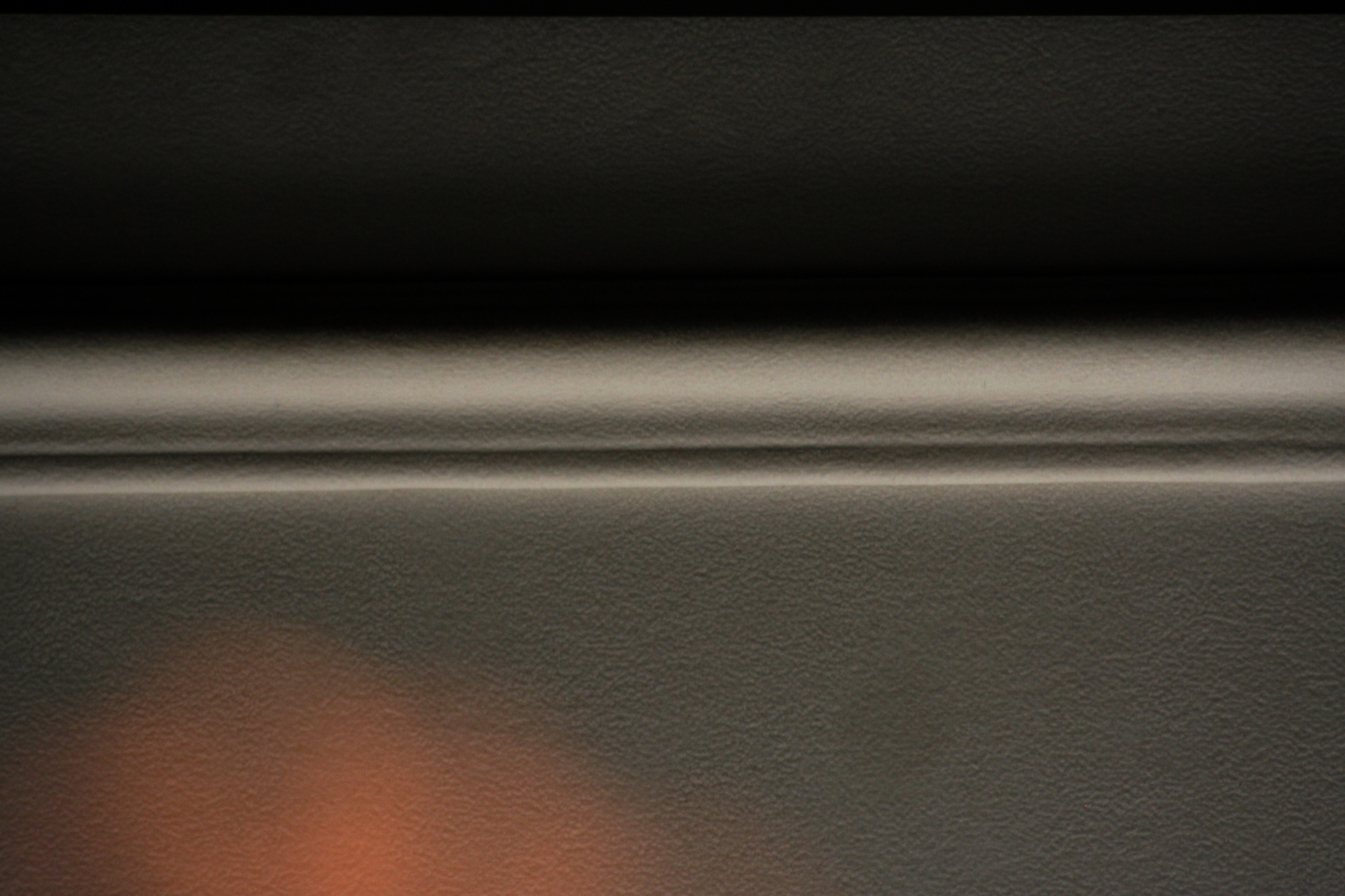 A grey ledge in shadow with a warm glow below