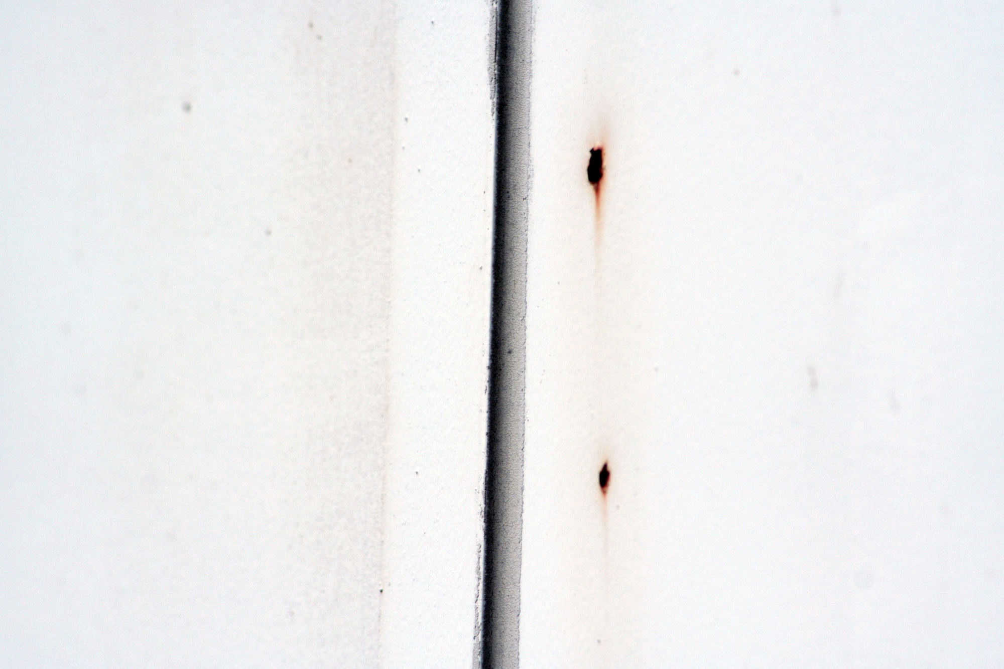 White panel with a black seam and rust marks
